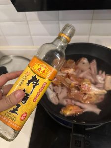 Trim the nails from the chicken feet, cut them in half, and place them in a pot of cold water with the chicken pieces. Add ginger slices, Sichuan peppercorns, scallion segments, an