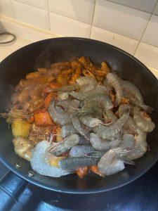 Add the shrimp and any greens you like, stir-fry for 8 minutes, then plate. If you like sesame, scatter a ring of sesame seeds over the top.