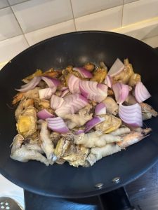 Add the chicken feet, chicken, and onion to the wok and stir-fry over high heat until fragrant.