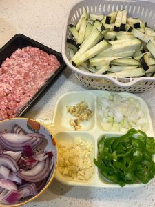 Prepare the minced pork, scallion, ginger, garlic, green pepper, onion, and eggplant, cutting the eggplant into even strips.