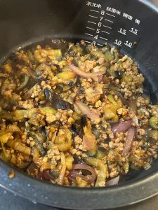 When the rice has about ten minutes left, cover it with the eggplant and pork mixture.