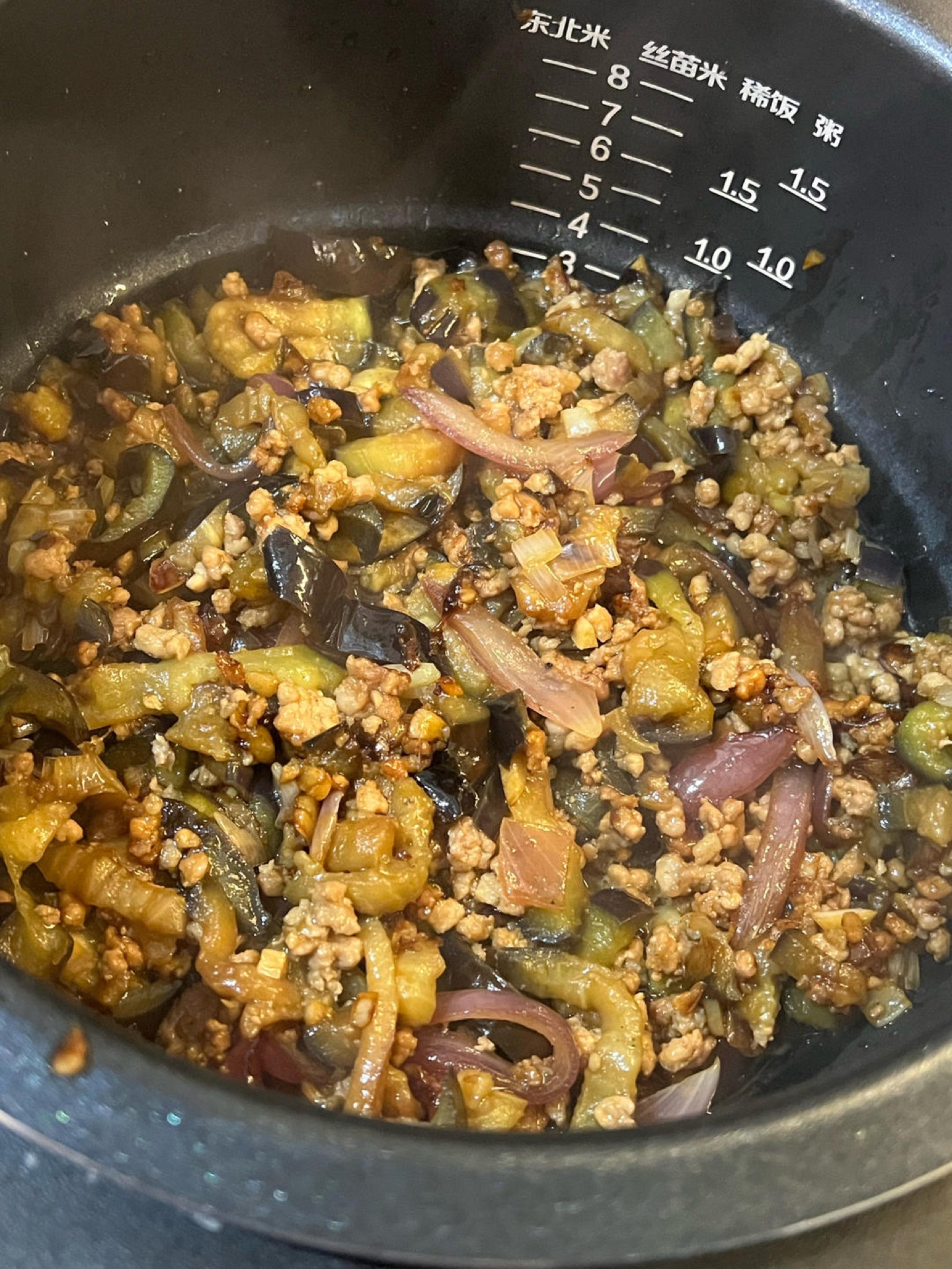 When the rice has about ten minutes left, cover it with the eggplant and pork mixture.