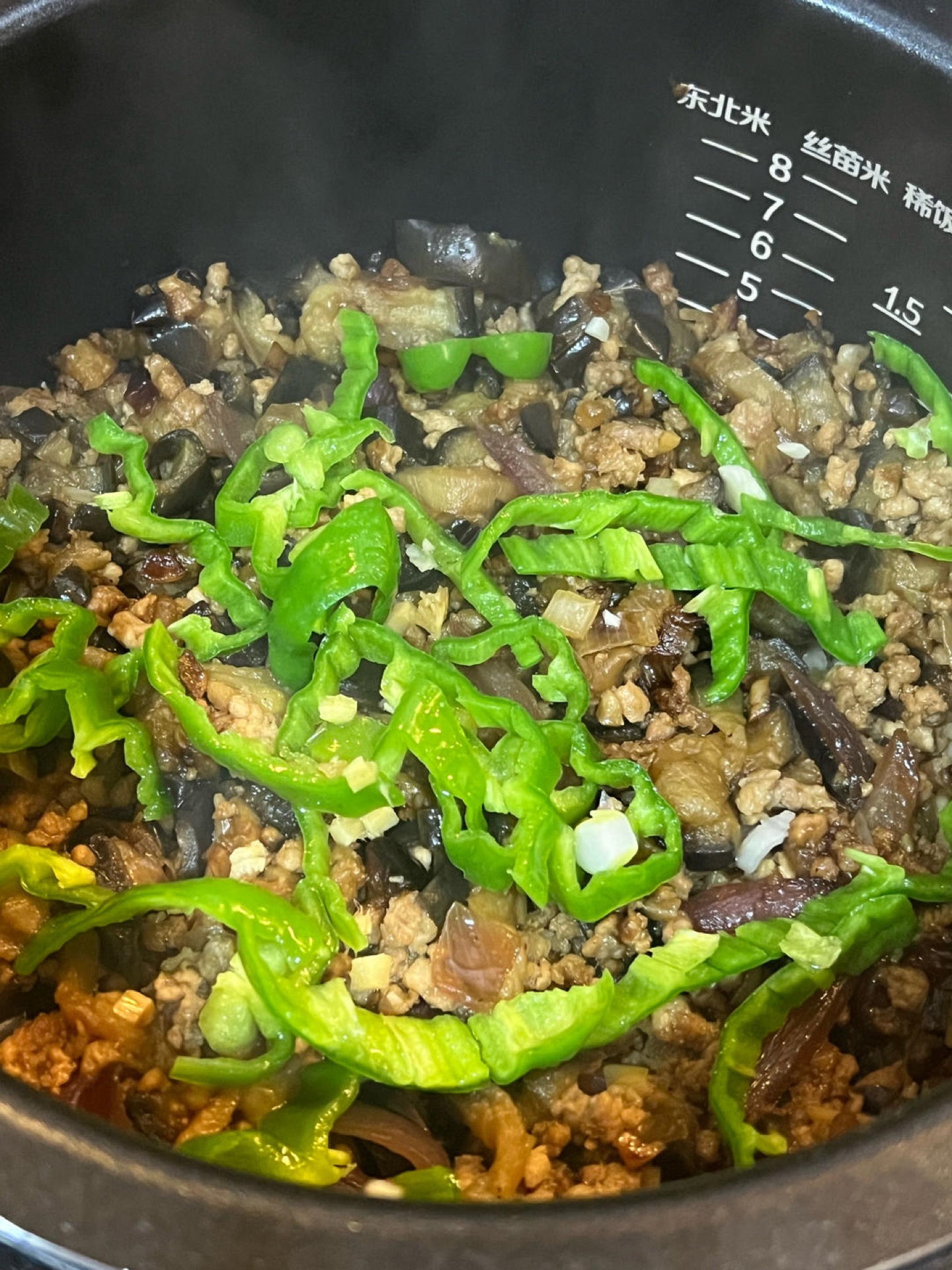 Steam for another ten minutes, then add the green pepper and the remaining scallion, ginger, and garlic, and stir to combine.