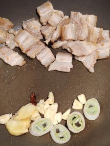 Tilt the wok so the rendered fat pools, and fry the aromatics in that oil, remembering to add the soul ingredient: two star anise.