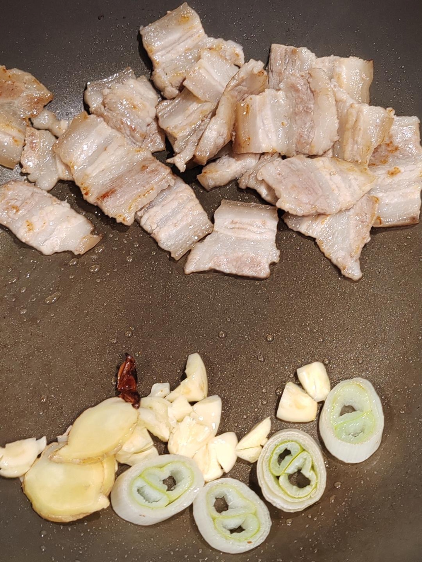 Tilt the wok so the rendered fat pools, and fry the aromatics in that oil, remembering to add the soul ingredient: two star anise.