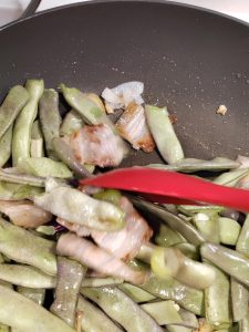 Add the green beans and stir-fry until evenly coated, splash in the soy sauce, add the salt, stir well, then pour in water until the beans are completely submerged; once it boils,