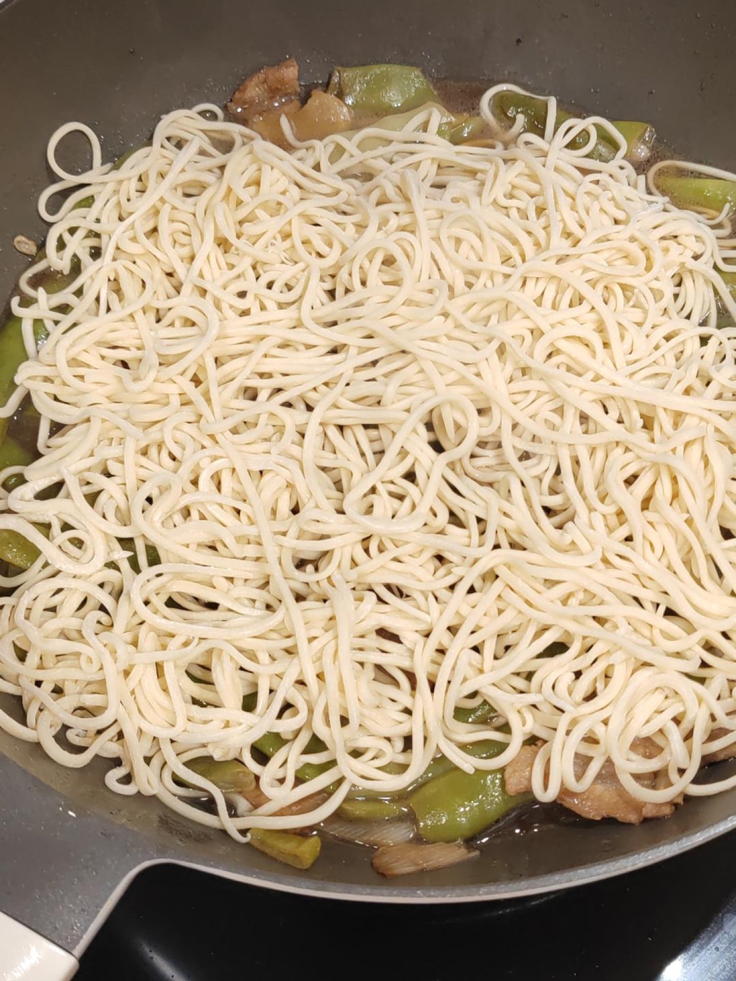 Remove the lid and spread the noodles loosely over the green beans, which should now be soft with the broth sitting beneath them, then cover and steam for about 5 more minutes.