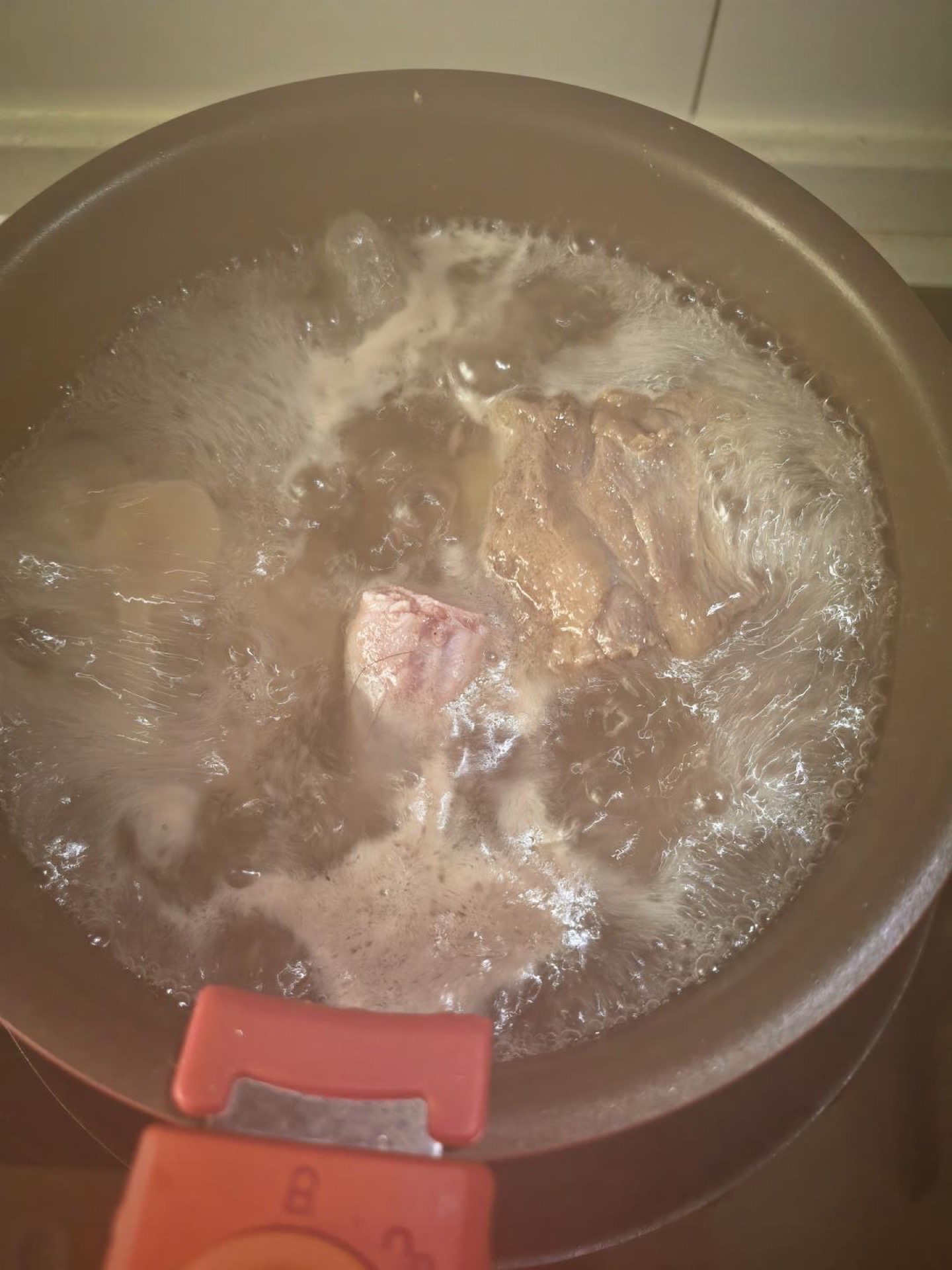 Blanch the oxtail in boiling water, then pressure-cook it for 10 minutes once the cooker comes up to pressure. Because I'm using a braising pot, I pressure-cook first — otherwise o