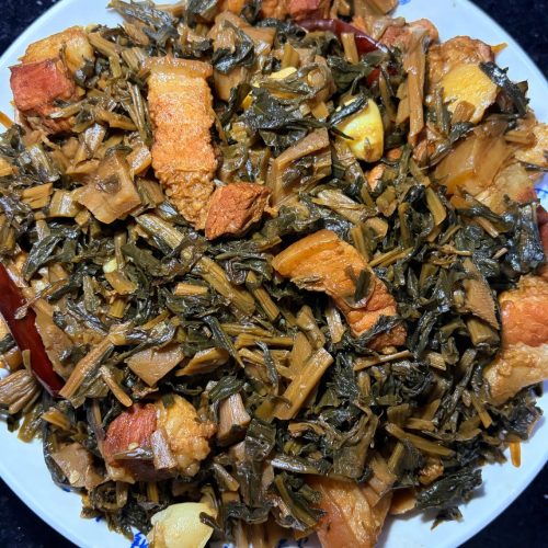 Braised pork belly with dried greens in a clay pot