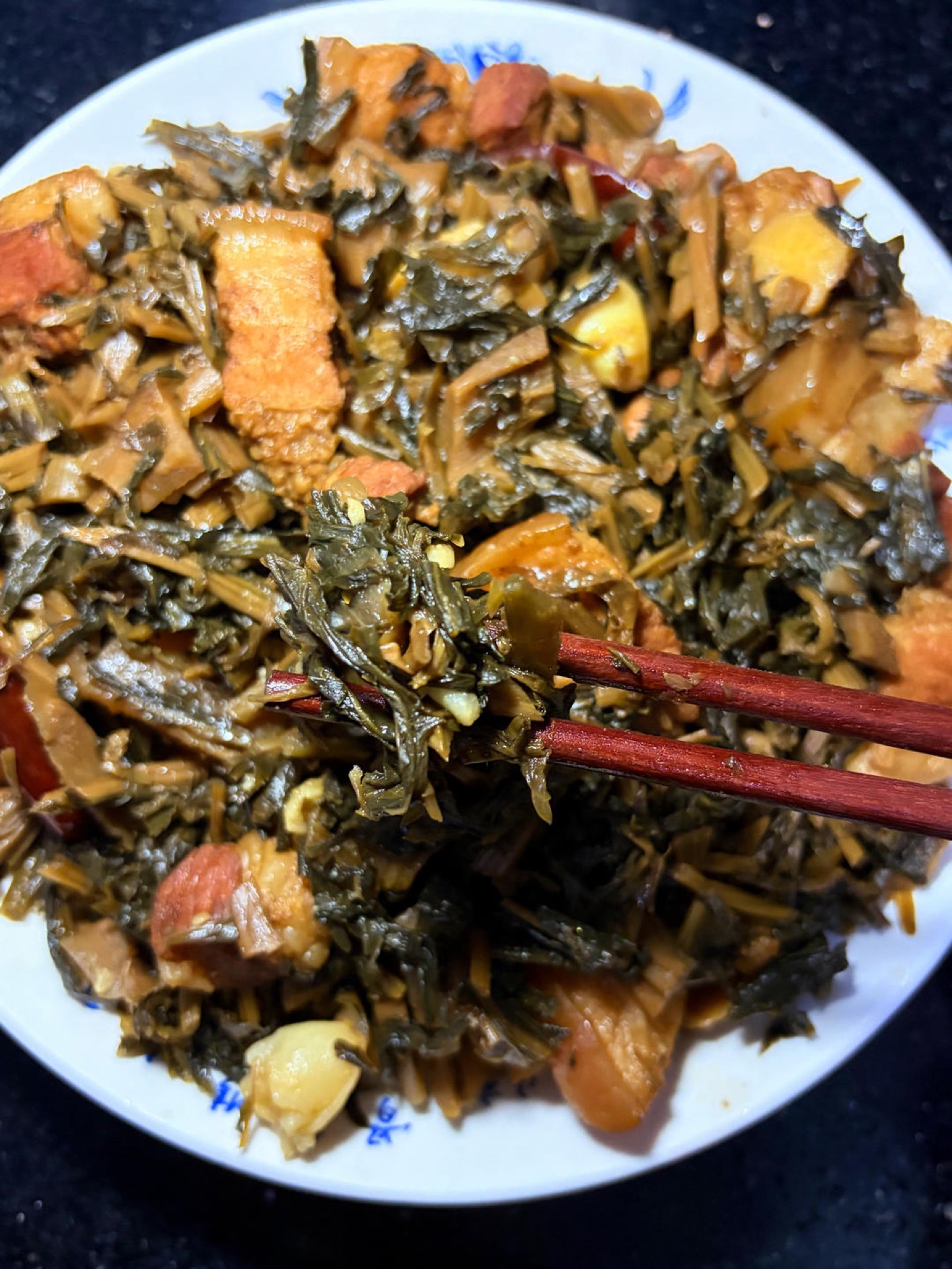 Finished braised pork belly with dried greens in the clay pot