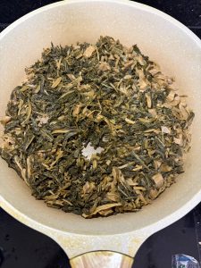 Toasting dried greens in a dry wok