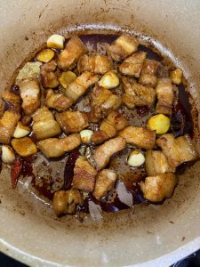 Pork belly coated in soy sauce in the wok