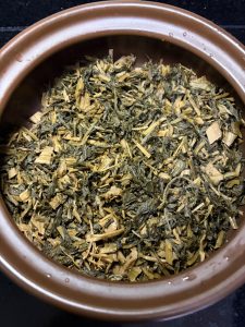 Greens spread across the bottom of a clay pot