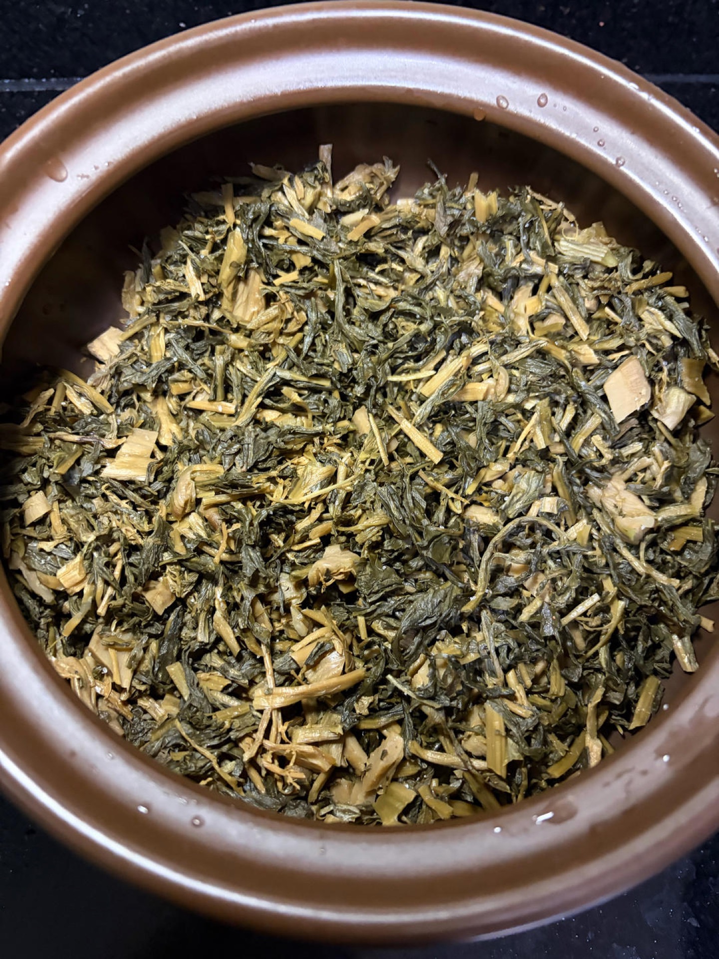 Greens spread across the bottom of a clay pot