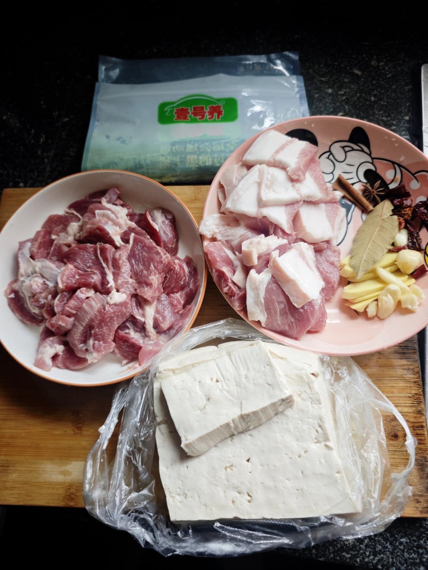 Cut the pork into bite-sized pieces, keeping the lean and fatty portions separate, and line up the ginger, garlic, dried chili, star anise, cinnamon bark, bay leaf, and chili paste