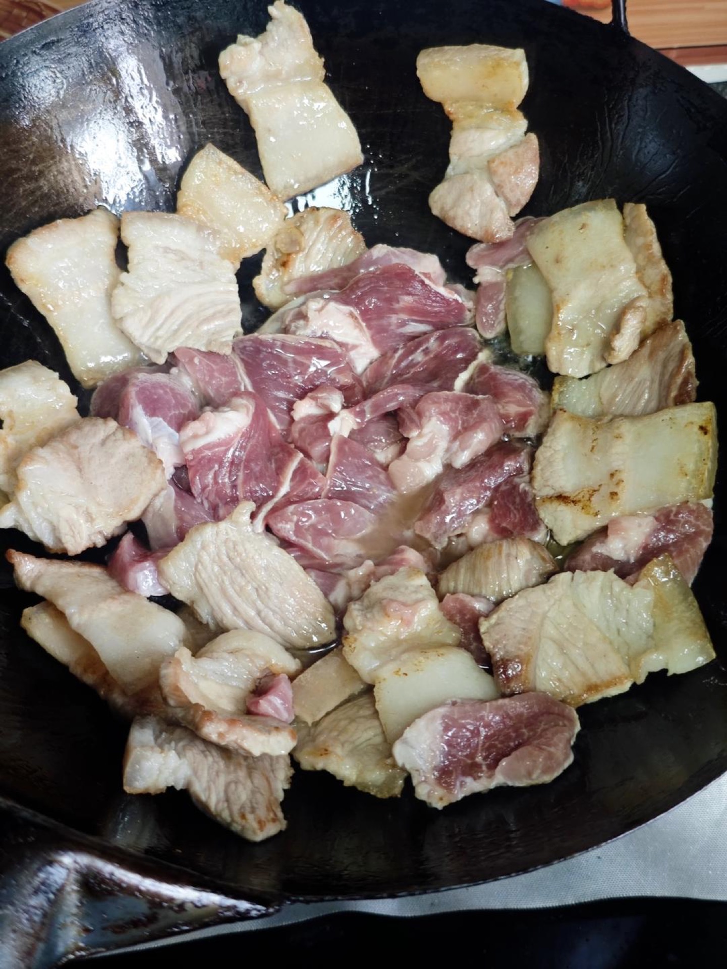 Once both sides are browned, add the lean pork and stir-fry until it changes color.