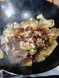 Pour in the light soy sauce for seasoning and the dark soy sauce for color, splash a little vinegar down the side of the wok (it tenderizes the meat and reacts with the soy sauce —