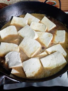 Add the cut tofu and lay the pieces out in an even layer.