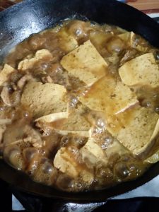 Use the spatula to spoon the braising liquid over the tofu so it soaks up the flavor, cover, and simmer for 15 to 20 minutes, watching the liquid so it does not dry out; taste and