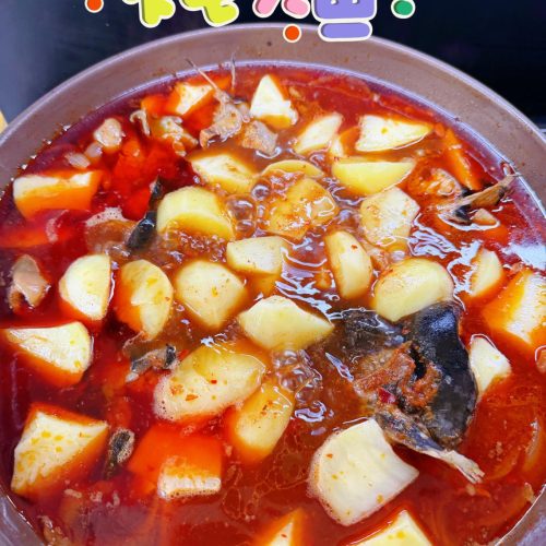Braised river fish in a dark pot with red chili oil and potatoes