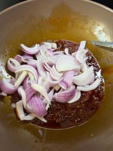 Onion and sauces added to the wok with the doubanjiang base