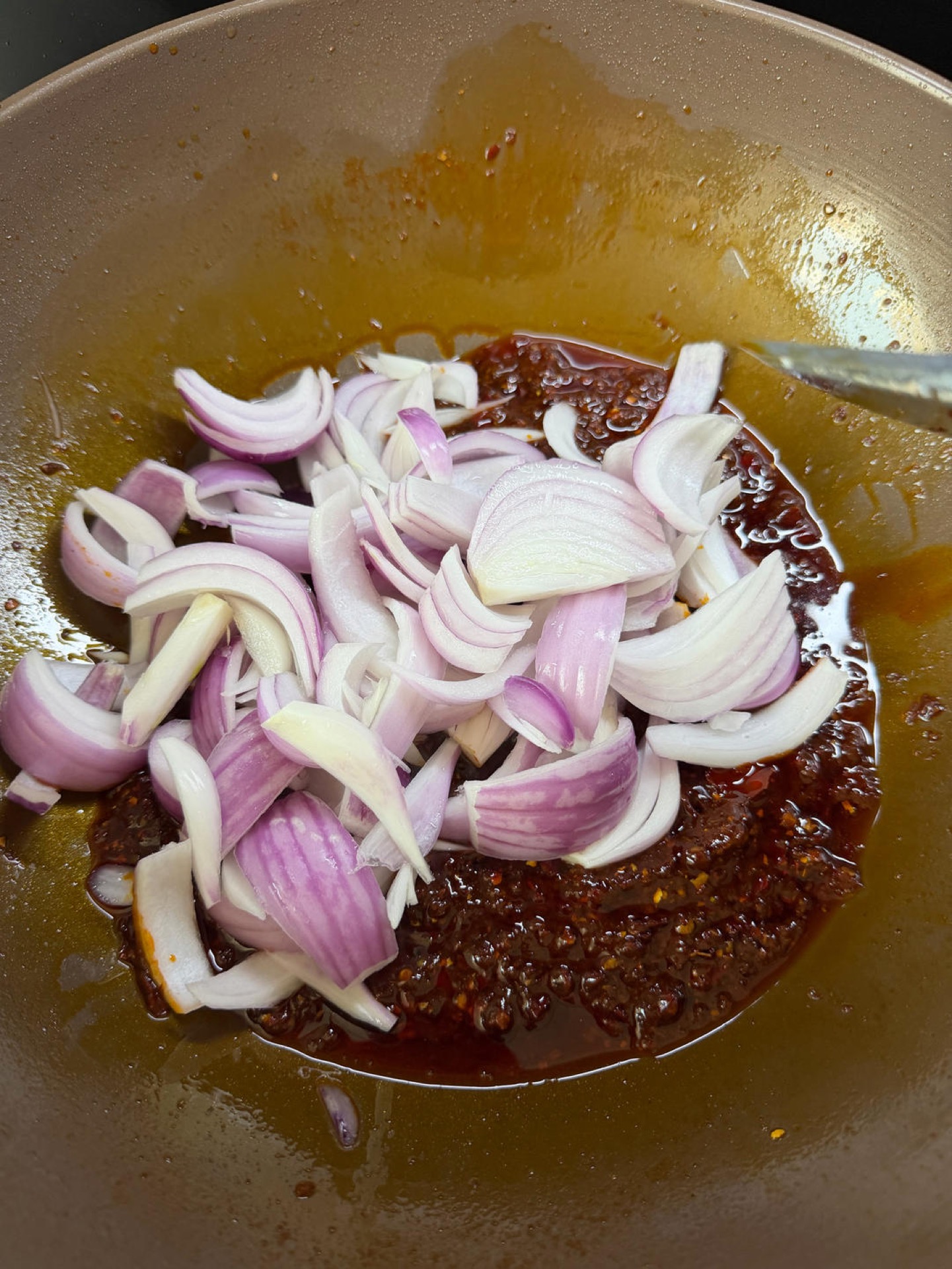 Onion and sauces added to the wok with the doubanjiang base