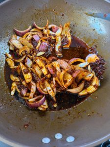 Aromatic sauce base spread evenly across the bottom of a heavy pot
