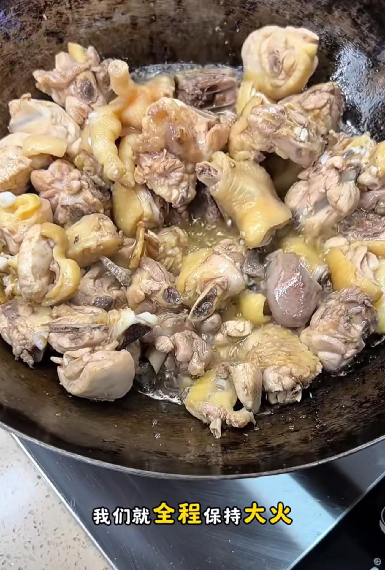Searing chicken pieces in a wok