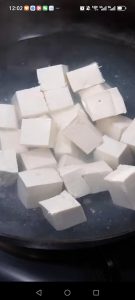 Slide the tofu into boiling water and blanch for 2 minutes, then lift it out and drain.