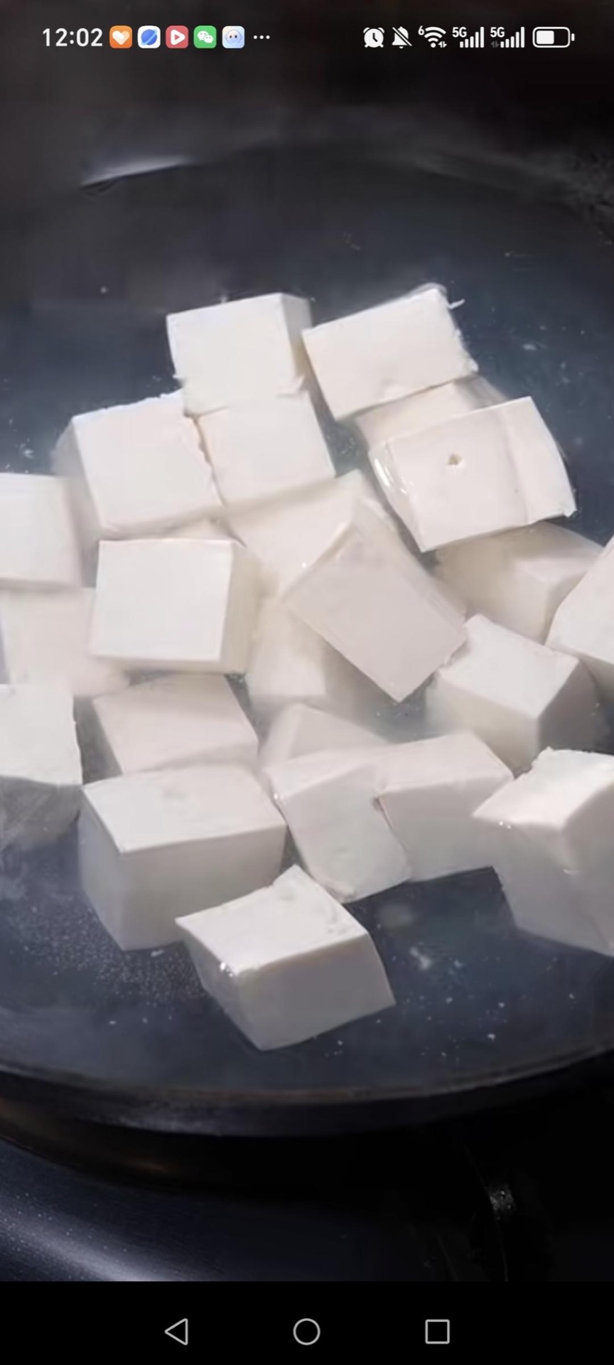 Slide the tofu into boiling water and blanch for 2 minutes, then lift it out and drain.