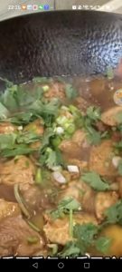 Uncover the wok and scatter over the scallions, small green chilies, and cilantro.