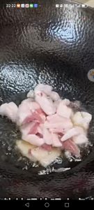 Add a little more oil to the wok, then add the sliced pork belly and fry it until it turns crisp and browned.