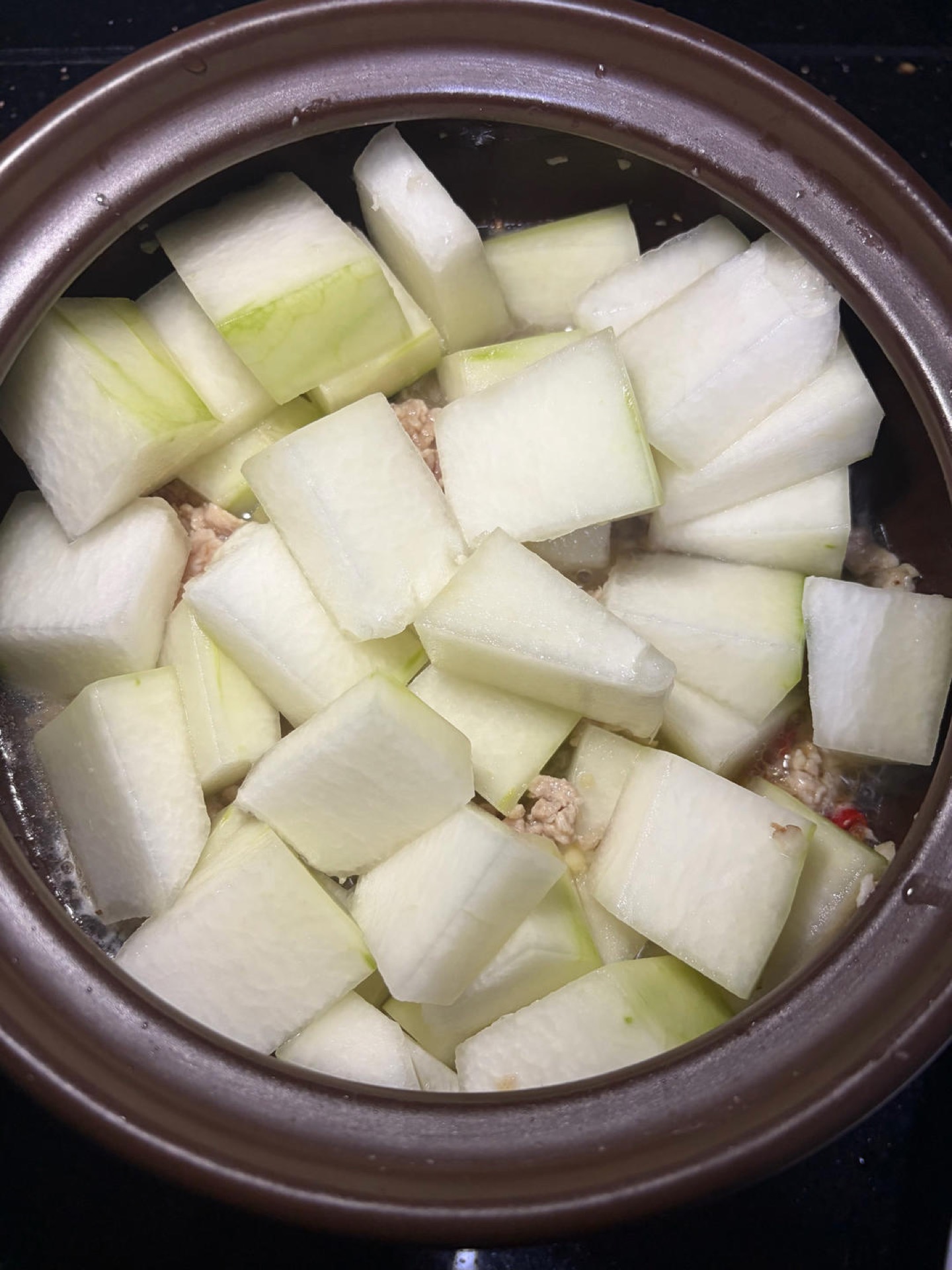 Add the winter melon cubes and pour in about half a bowl of water, no more, because the melon will release its own liquid.