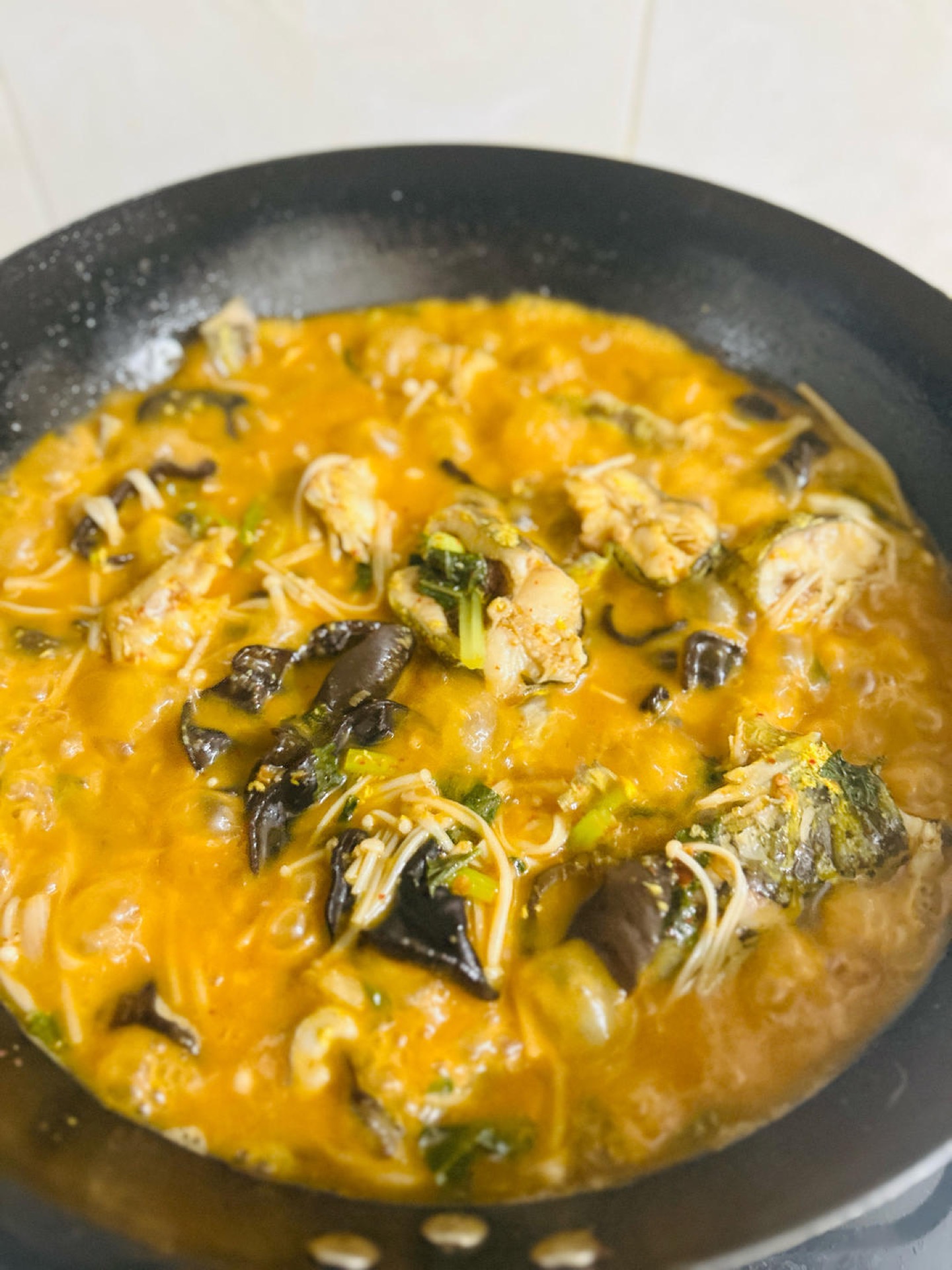 Fish and vegetables turned gently in the pan