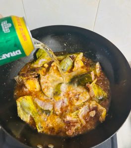 Beer poured over the fish in the pan