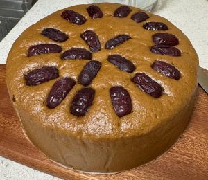 Tall golden-brown steamed cake with red dates on top