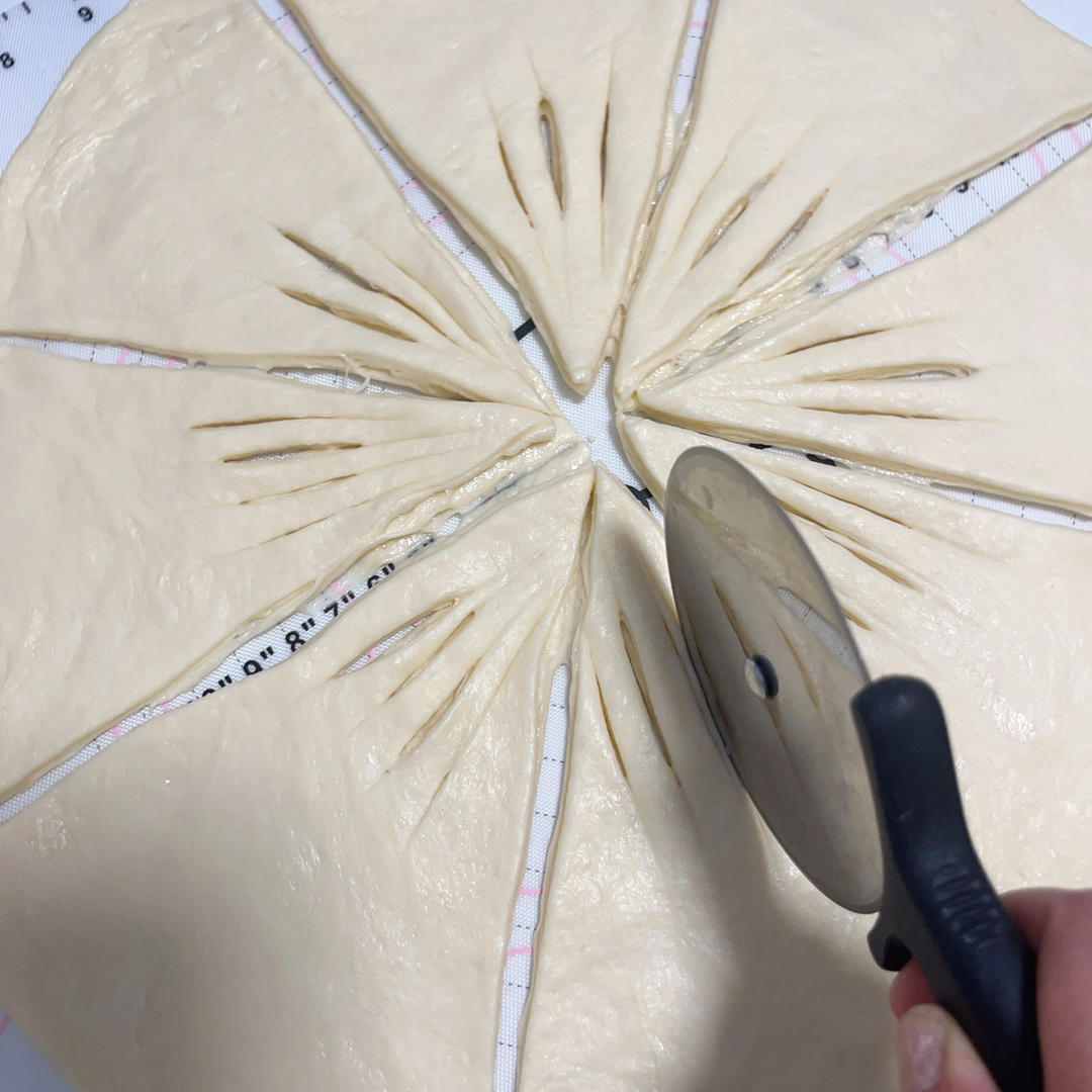 Making shallow cuts along each dough wedge