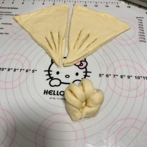 Pinching the ends of each roll into horn shapes