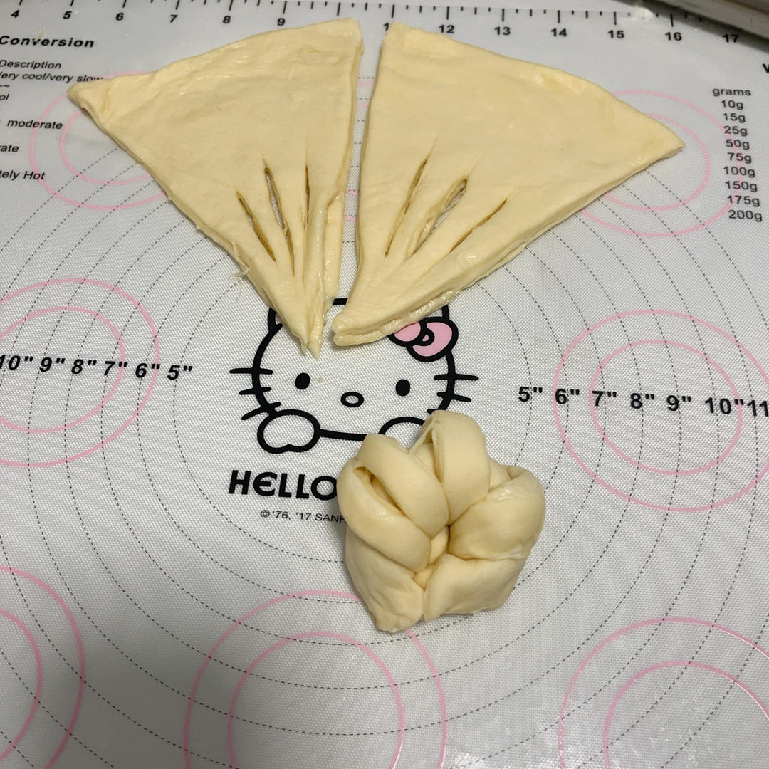 Pinching the ends of each roll into horn shapes