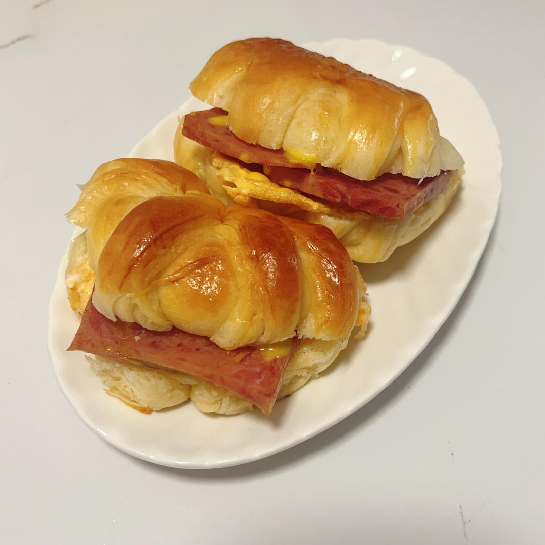 Splitting a butter bread bun to fill with egg and luncheon meat