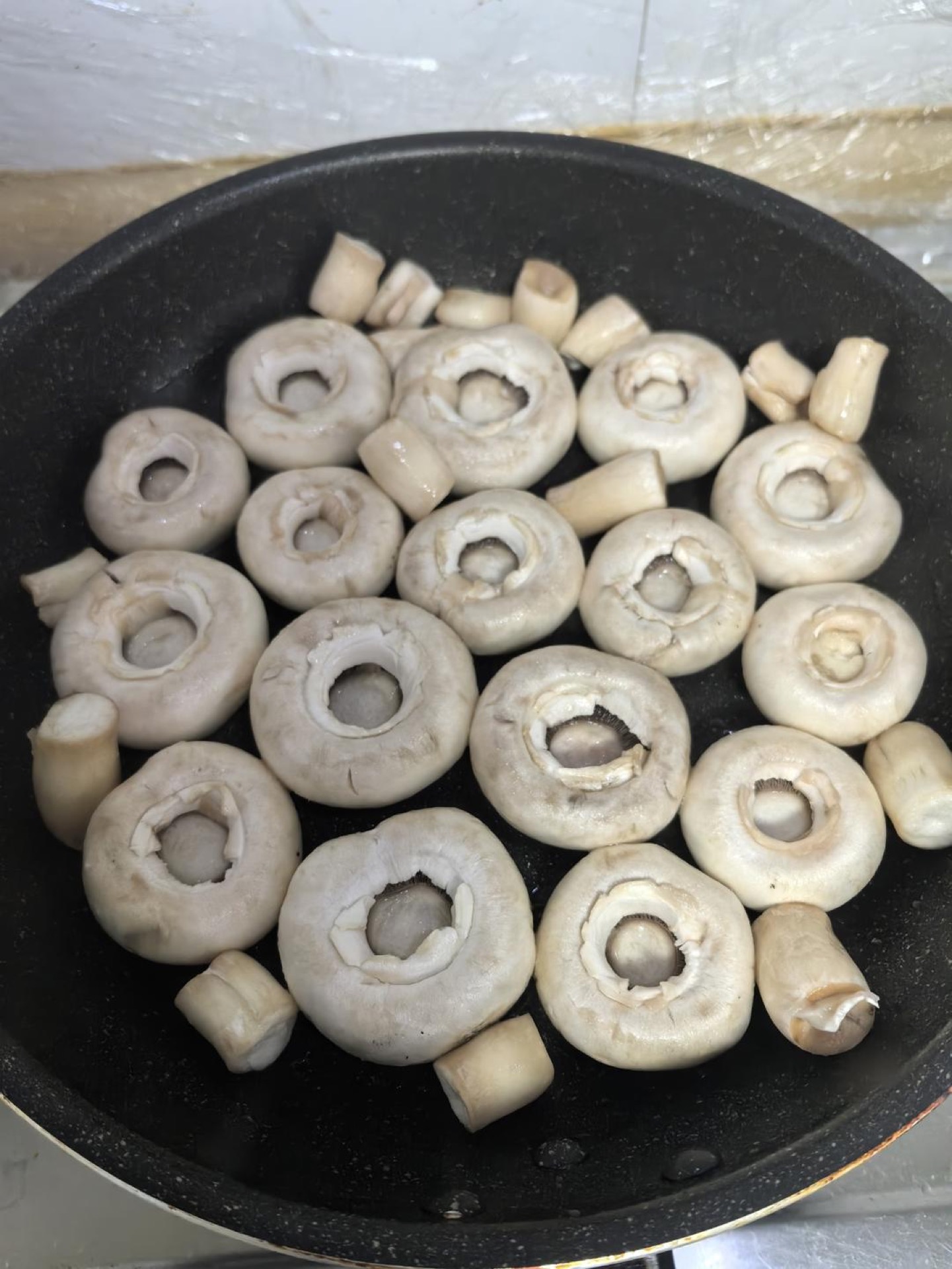 Wash the mushrooms well, add a little oil to the wok, and sear over low heat.