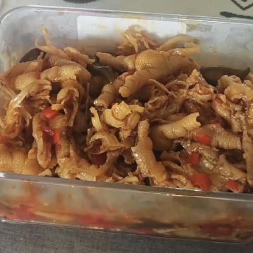 Camellia oil hot and sour boneless chicken feet in a glass bowl, tossed in a glossy red chili dressing