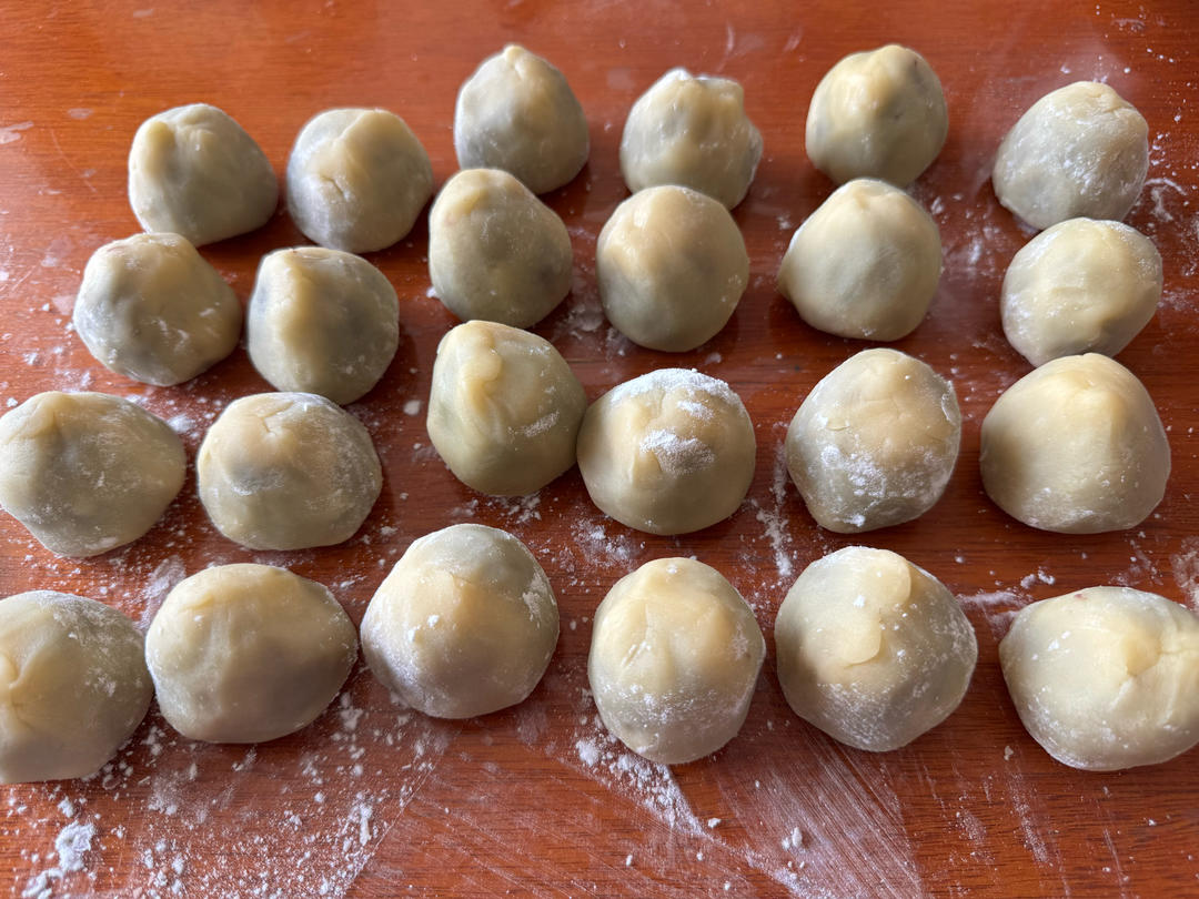 Filling being wrapped in the mooncake dough