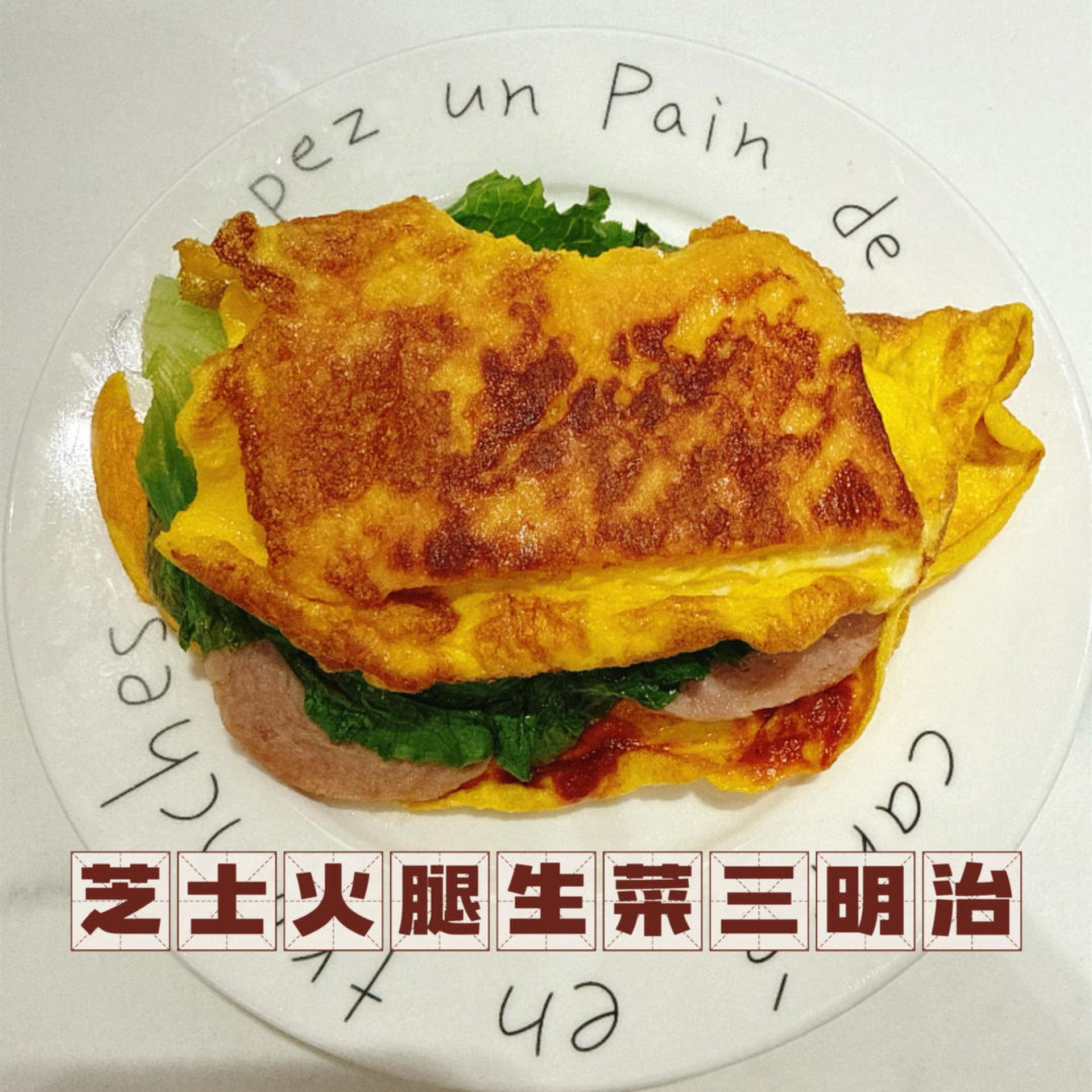 Cheese ham lettuce egg toast on a plate with a molten cheese pull and crisp lettuce