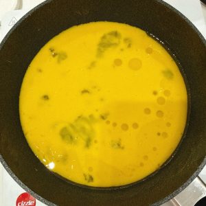 锅中刷油倒入蛋液。