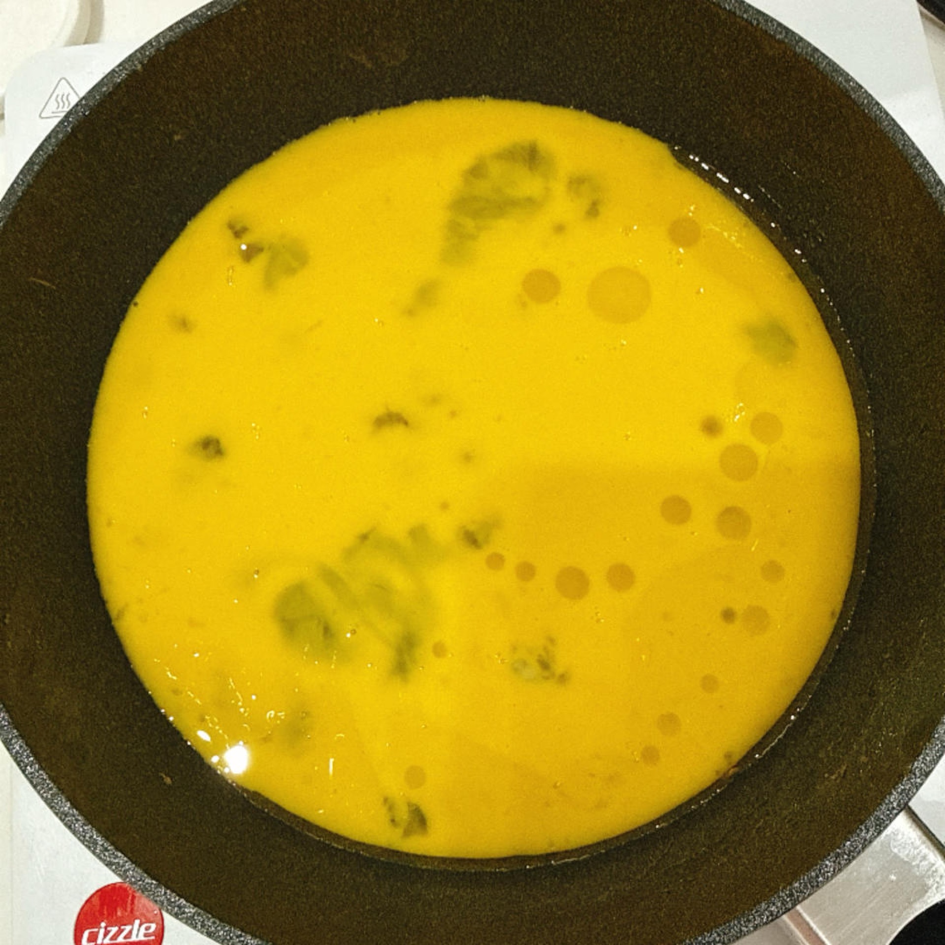 锅中刷油倒入蛋液。