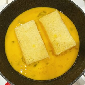 吐司一切二放入蛋液中。