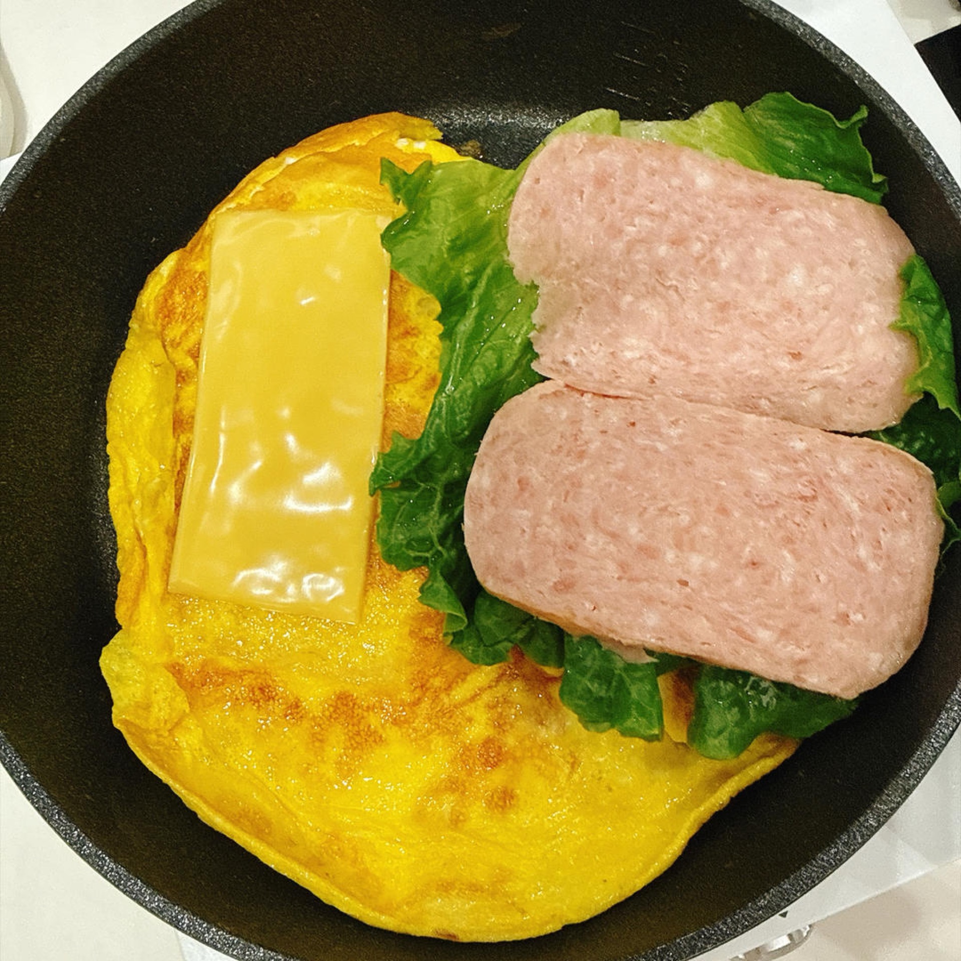 摆上生菜,放午餐肉对半切开摆上。
