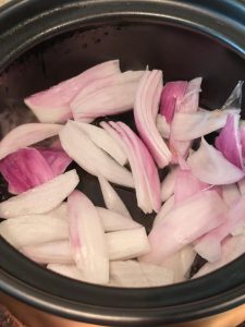 Onion sliced in the bottom of a clay pot