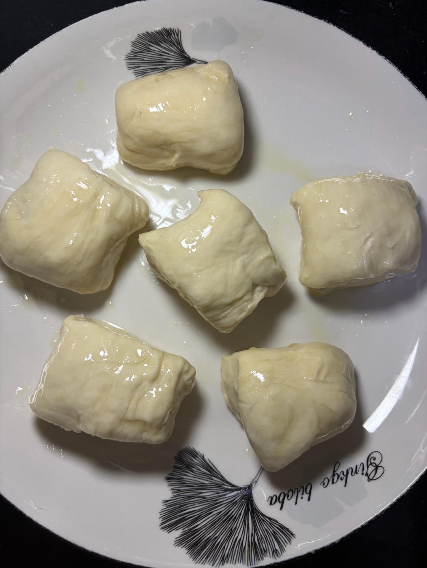 Roll the dough into a long log and cut it into 6 equal pieces, then brush a thin layer of oil over the surface of each piece.
